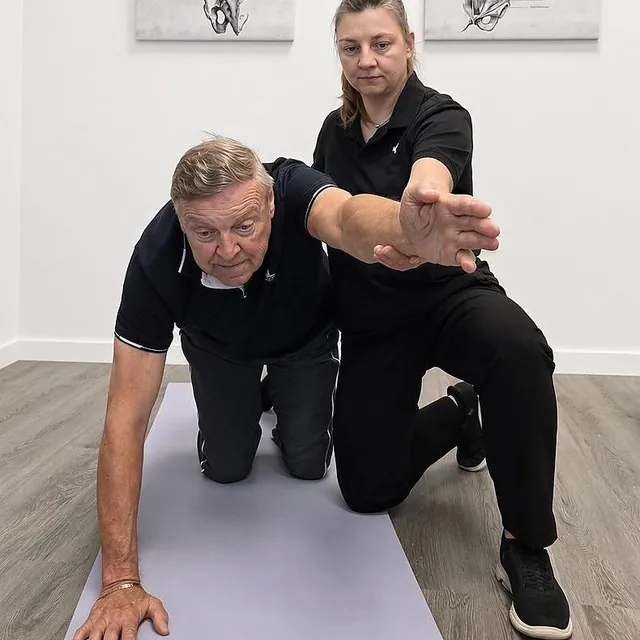 Aneta Zawadzka guiding a patient through a shoulder and balance exercise at Go2physio North Vancouver